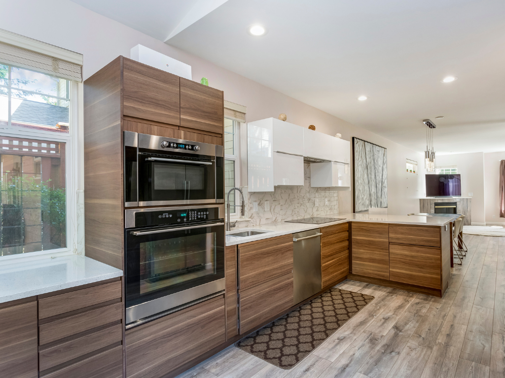 A modern kitchen featuring wooden cabinets and sleek stainless steel appliances, creating a warm and stylish atmosphere.